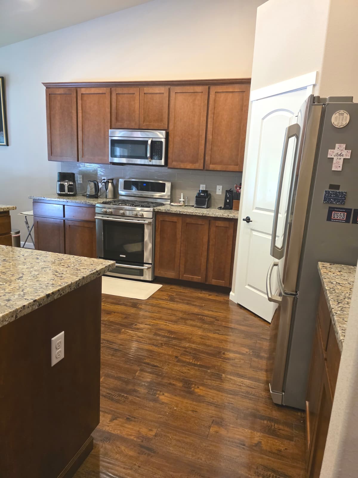 Modern kitchen with wooden cabinets, granite counters, and stainless appliances